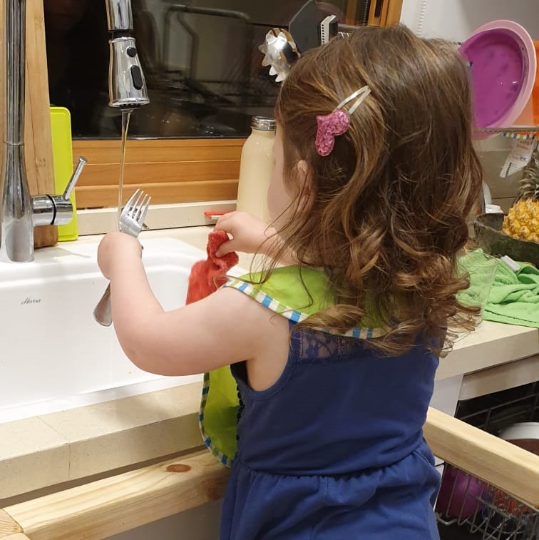 ילדה שוטפתת כלים